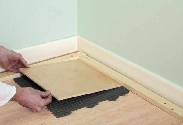 Процесс укладки керамической плитки на деревянный пол