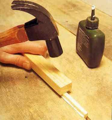 Забивание рейки в щель обычным молотком через деревянную прокладку