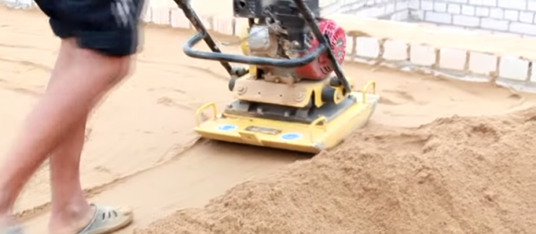 Трамбовка песчаной засыпки